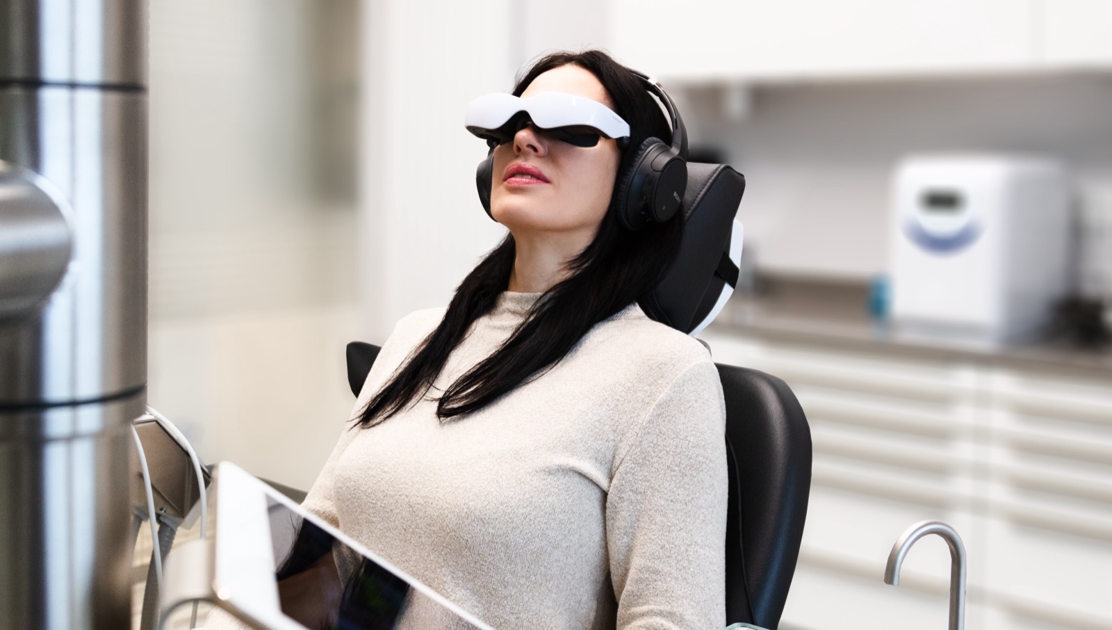 Patientin entspannt mit Videobrille im Behandlungsstuhl